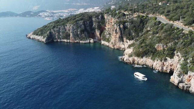 Aerial view of gorgeous Buyuk Chakil (black pebble) beach with emerald clear waters and boats, Kas, Turkey
