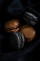 Sweet macaron dessert on black fabric napkin.