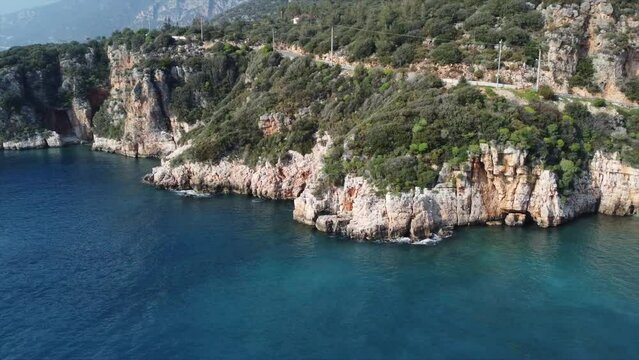 Aerial view of gorgeous Buyuk Chakil (black pebble) beach with emerald clear waters and boats, Kas, Turkey