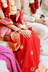 Naklejka premium Indian man and woman in festive traditional dress and costume, sitting together during wedding ceremony