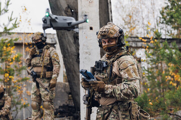 Military soldier controls drone for reconnaissance operation of enemy positions. Concept using quadrocopters in smart war