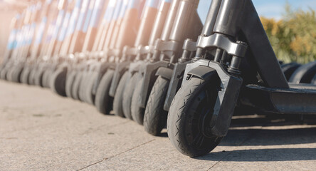 Row rent electric scooters parked on city street rental service. Concept banner eco energy transport © Parilov