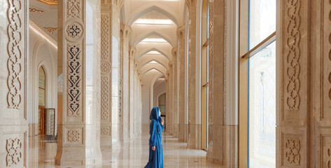 Modern woman in traditional blue abaya standing in Grand Mosque. Concept traveling by Astana...