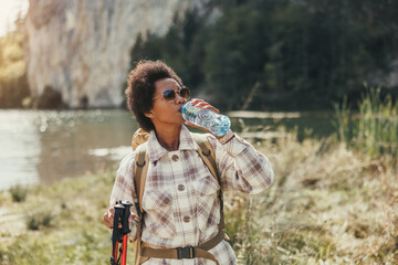 Woman Standing Near A Lake And Drinks Water
