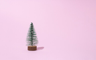 Christmas tree isolated on pastel pink background. Wintertime. Holiday concept. Copy space.