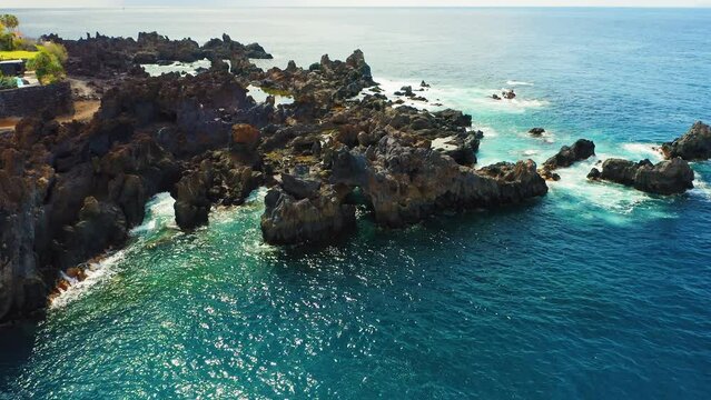 Aerial sunset light. Rocks sticking out of the ocean. Tenerife, Canary Island, Charco el Diablo or natural pool of Devil. Cueva la Vaca. Lava frozen, volcanic bizzare stony beach. Touristic spot.