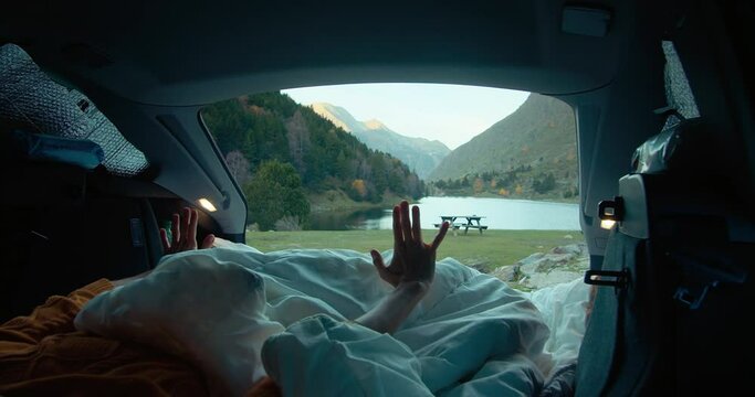 Woman wake up in vehicle trunk on autumn mountain road trip on lakeshore