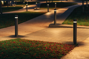 Row Of Outdoor Landscape Hard Paving Light. Lighting element on the green lawn along the footpath. Modern lighting system in landscape design.