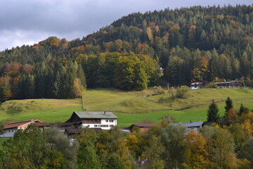 A valley with small mountain houses in the middle of the green