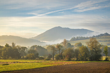 Obraz premium Rural landscape in an autumn foggy morning. Northwest of Slovakia, Europe.