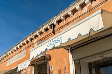 Obraz premium Murano Glass Word on shop in Murano Island, Venice. Murano glass blowing factory. Workers.