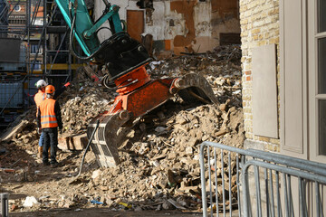 Ruined destroyed house. An excavator destroys a house with a bucket.