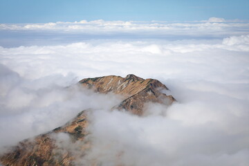 A mountain ridge like floating in a fantastic sea of clouds in autumn