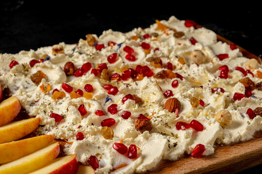 Trendy sweet butter board. Village cottage cheese, nuts, dried fruits, pomegranate seeds, flower petals and apple slices.