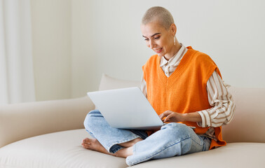 Full height of beautiful woman freelancer  with very short hair   resting at laptop at home
