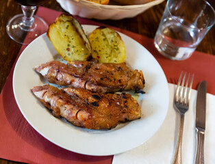 Pig's trotter with potato cooked and served on table in restaurant.