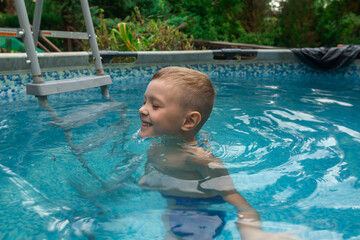 Young kid having fun in the swimming pool.  outdoor pool with cold water