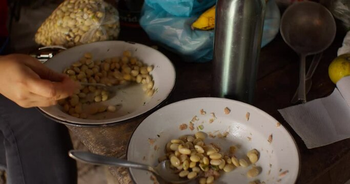 Woman stirs tarwi in plate