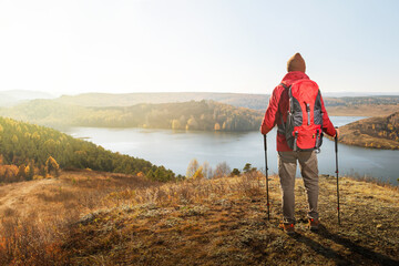 Man hiking at sunset mountains with backpack. Travel lifestyle wanderlust adventure concept.