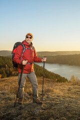Man hiking at sunset mountains with backpack Travel Lifestyle wanderlust adventure concept