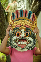 little girl with an Indonesian mask