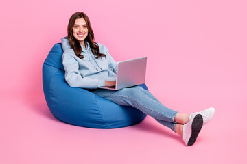 Full body photo of cheerful lovely lady sit comfort bag use wireless netbook isolated on pink color background