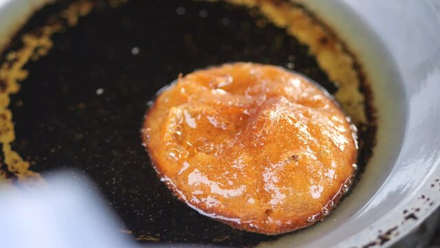 The making of Sabah Borneo Sweet Traditional Cake called Penjaram or Cucur Gula Merah fry in deep hot oil.