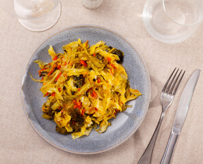 Traditional stewed white cabbage with vegetables served on plate. Delicious vegetarian food.