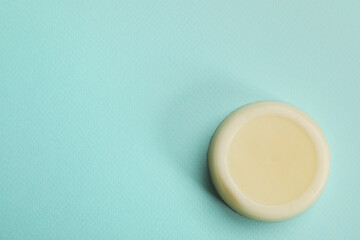 Obraz na płótnie Canvas Solid shampoo bar on turquoise background, top view. Space for text