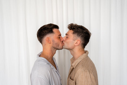 Beautiful Gay couple kissing with white curtain background