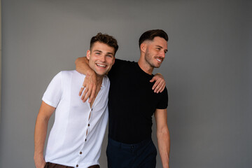 beautiful gay couple smiling and arms around shoulders 