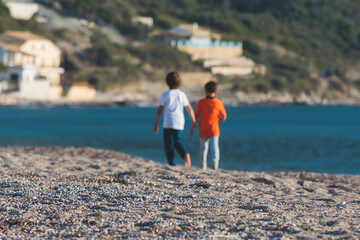 Two best friends kids having fun on the beach in the summer holidays vacation, concept of child friendship, boys playing together
