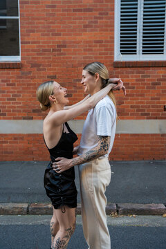 cool lesbian couple slow dancing in the city and laughing
