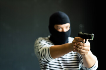 Masked robber with gun. Concept of crime and fire arm assault with mature man. Armed robbery on...