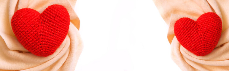 Wide banner with red crochet hearts and soft warm beige scarf, white background with copy space. Love , romance, wedding, boho style