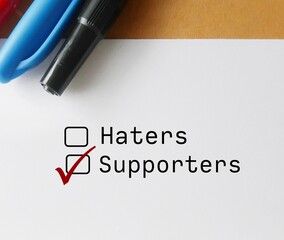 White paper note with tick box and choose SUPPORTERS over HATERS, means stop focusing and trying to...