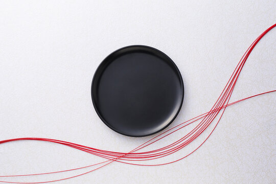 白い背景に赤い水引と黒いお盆