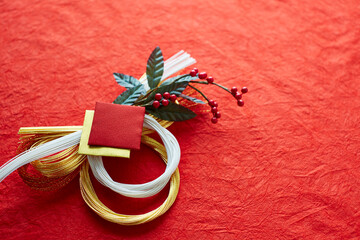 赤い和紙上の水引の正月飾り