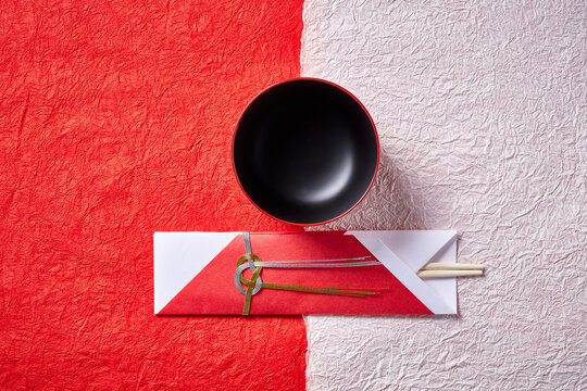 紅白の和紙に置かれたお椀と祝い箸