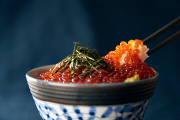 いくら丼にイクラを盛っている