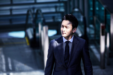 スーツ姿でオフィスエリアを歩くビジネスマン