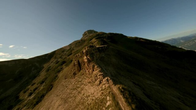 Fpv flight along rocky summit of Mountain Bondone during golden sunset in Dolomites
