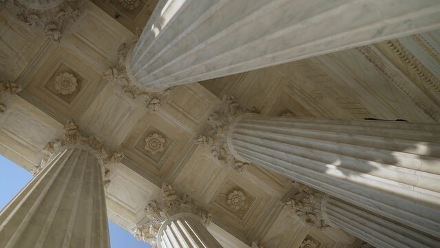 Looking Up At The Top Of Corinthian Columns In Front Of US Supreme Court In Washington, DC, Showing Power Over People And Business.