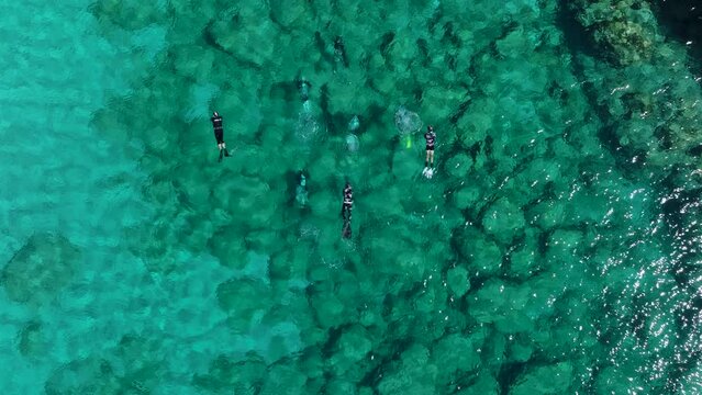 Snorkelers and scuba divers in crystal clear waters of Rhodes, Greece; aerial