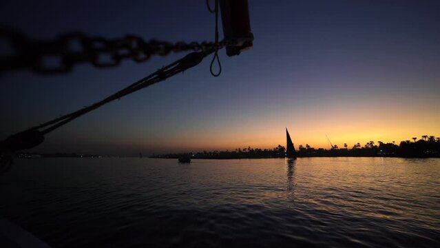 sail boat cruise along the Nilo river in Egypt during a stunning colourful sunset 