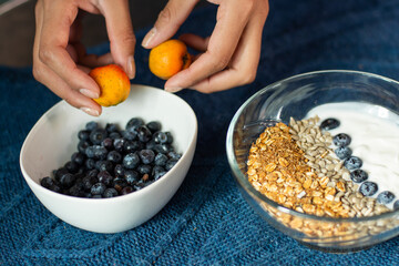 Unrecognizable person makes breakfast with blueberry and fruit