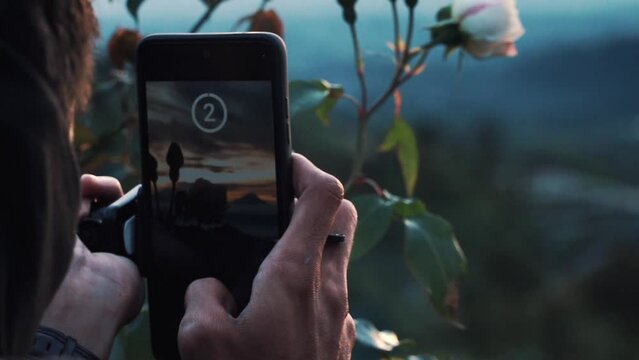 Static shot of a man taking landscape photo using smartphone. Slow motion.