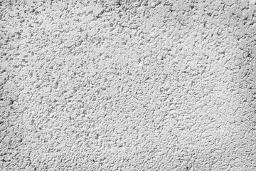Rough surface of a concrete wall painted in greyish white, concrete wall background, blurred white background.