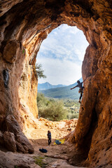 Extreme sport, strong man, rock climber climbs a difficult route.