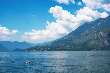 Fototapeta na wymiar Beautiful panoramic view of the speed boat cruising along Lake Lugano, with the green Swiss Alps in the background on a sunny summer day. Canton of Ticino, Switzerland.